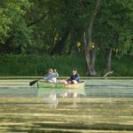 Kanu mit Angelausrüstung auf einem ruhigen See bei Morgenlicht